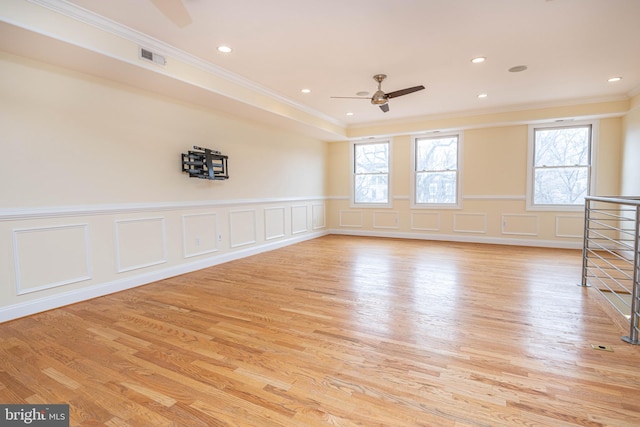 spare room with light wood-style floors, plenty of natural light, and ornamental molding