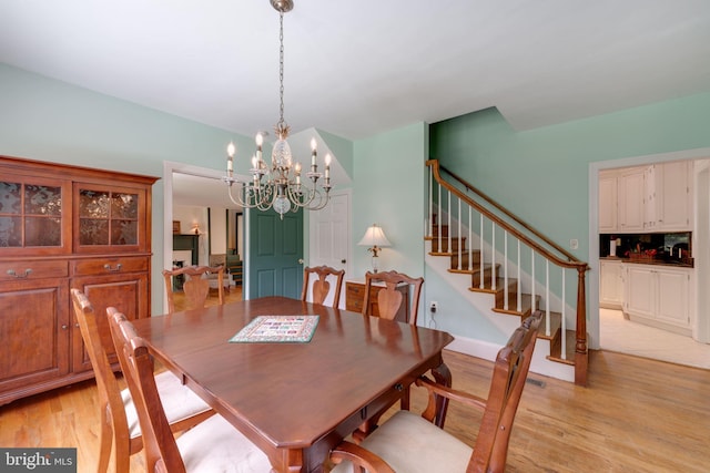 dining area featuring light wood-style flooring and stairs