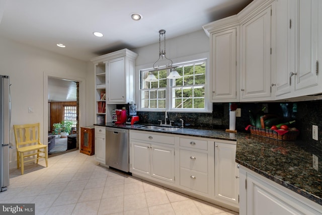 kitchen with white cabinets, backsplash, stainless steel appliances, and a sink