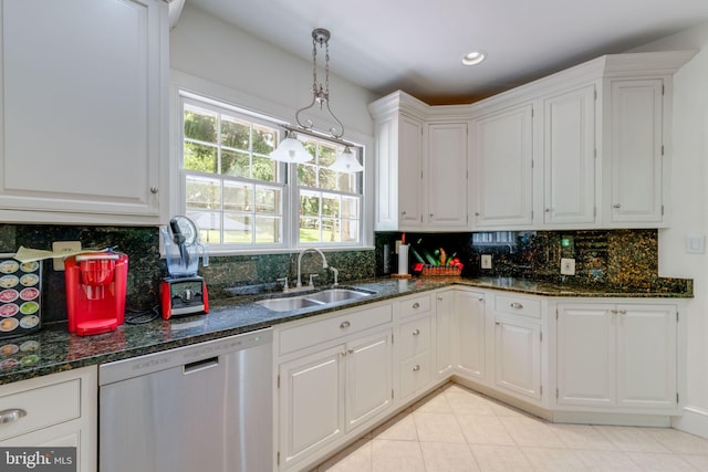 kitchen with decorative backsplash, stainless steel dishwasher, white cabinetry, a sink, and dark stone counters