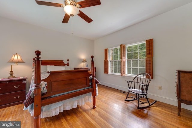 bedroom with visible vents, baseboards, and wood finished floors