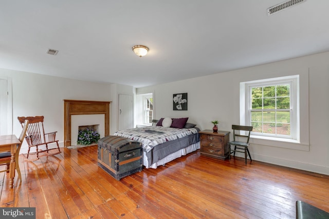 bedroom featuring visible vents, light wood-style flooring, and baseboards