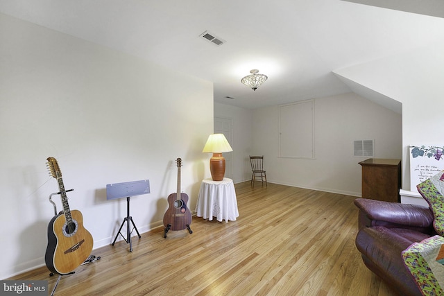 living area featuring light wood-type flooring, baseboards, and visible vents