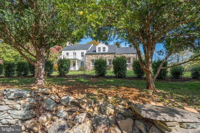 view of front of property featuring stone siding and a front yard