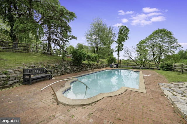 view of swimming pool featuring a fenced in pool, a patio area, a fenced backyard, and a yard