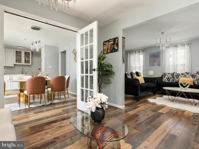 dining space with baseboards, wood-type flooring, and a chandelier