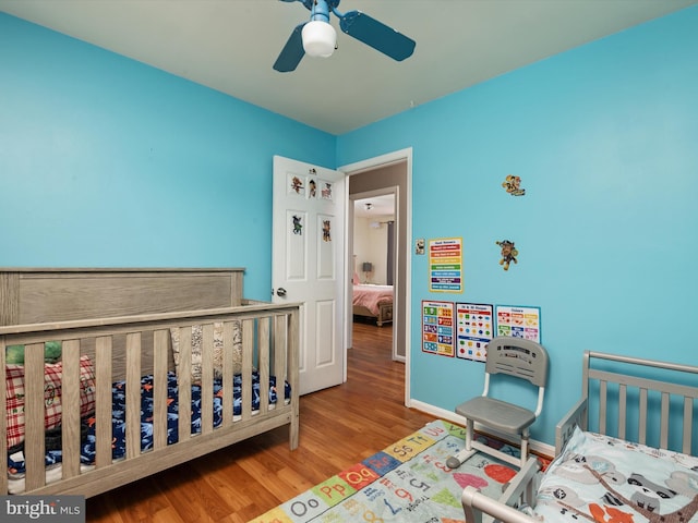 bedroom featuring ceiling fan, baseboards, and wood finished floors