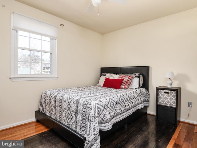 bedroom featuring ceiling fan, baseboards, and wood finished floors