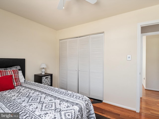 bedroom featuring wood finished floors, baseboards, a closet, and ceiling fan