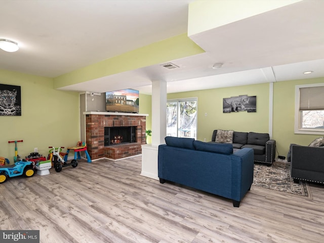 living room featuring visible vents, wood finished floors, and a fireplace