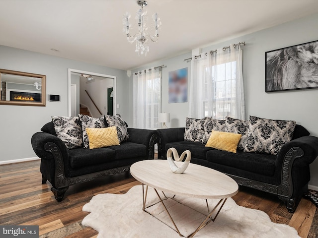 living area featuring wood finished floors, baseboards, and a chandelier