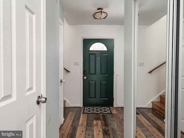 entrance foyer featuring dark wood finished floors, stairway, and baseboards