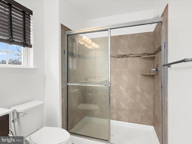 bathroom with a stall shower, vanity, and toilet