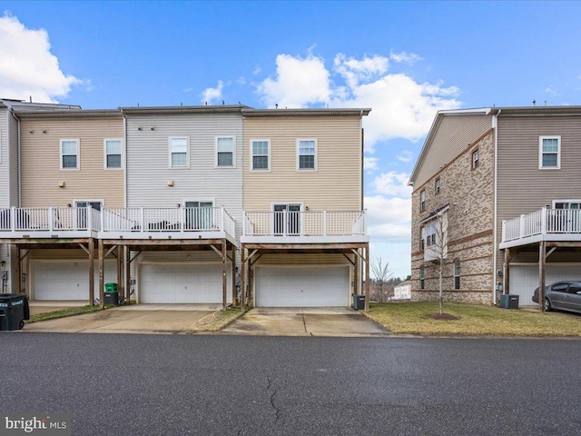 rear view of house with a yard, central AC unit, and an attached garage