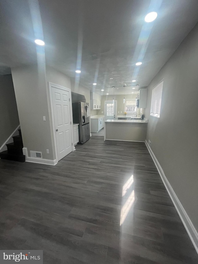 unfurnished living room featuring recessed lighting, visible vents, stairway, dark wood-type flooring, and baseboards