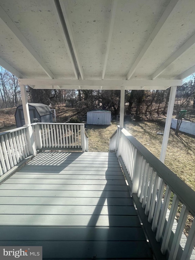 wooden deck with a shed and an outbuilding