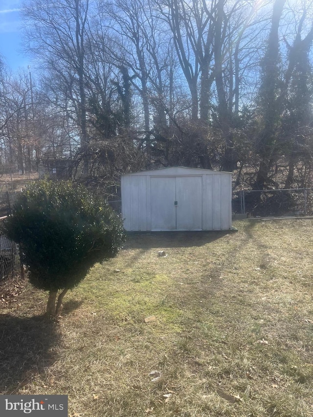 view of yard with an outbuilding, a shed, and fence