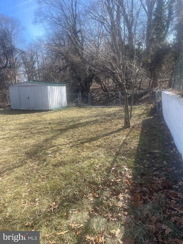 view of yard featuring a storage shed, an outdoor structure, and fence