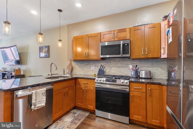 kitchen featuring a sink, appliances with stainless steel finishes, and brown cabinetry