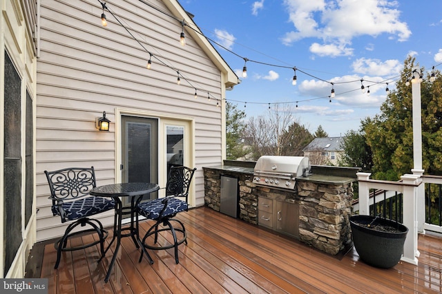 wooden terrace featuring exterior kitchen and area for grilling