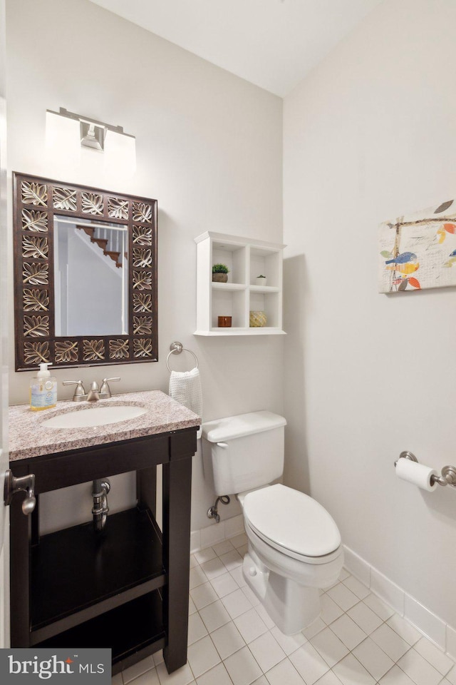 half bath featuring toilet, tile patterned flooring, baseboards, and vanity