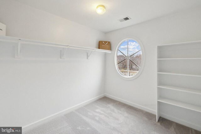 walk in closet with light carpet and visible vents