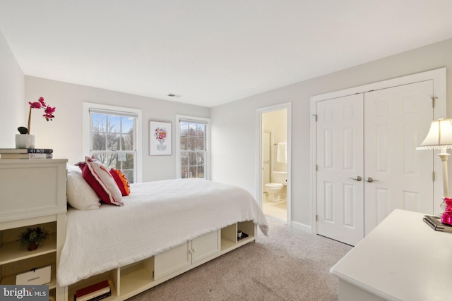 bedroom featuring carpet floors, a closet, and ensuite bath