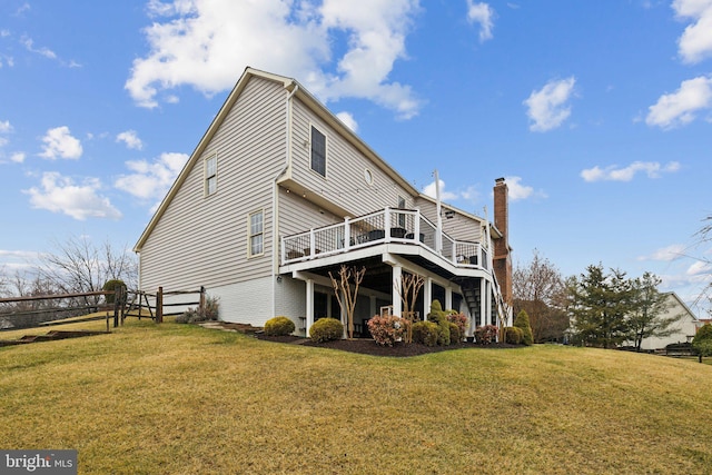 rear view of property with a lawn, fence, a wooden deck, and stairs