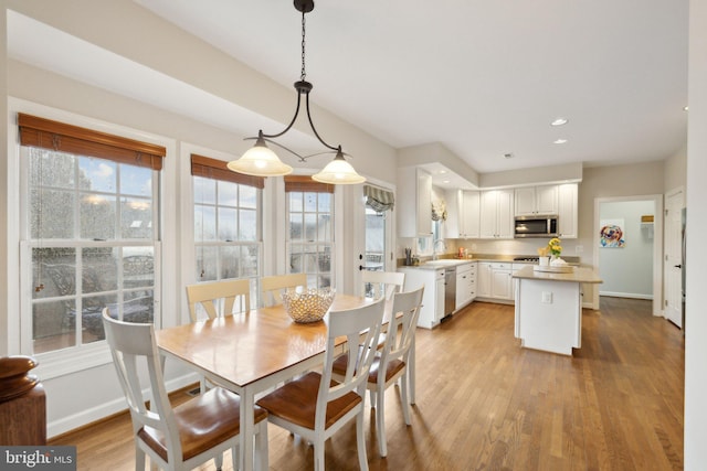 dining space with recessed lighting, baseboards, and light wood finished floors