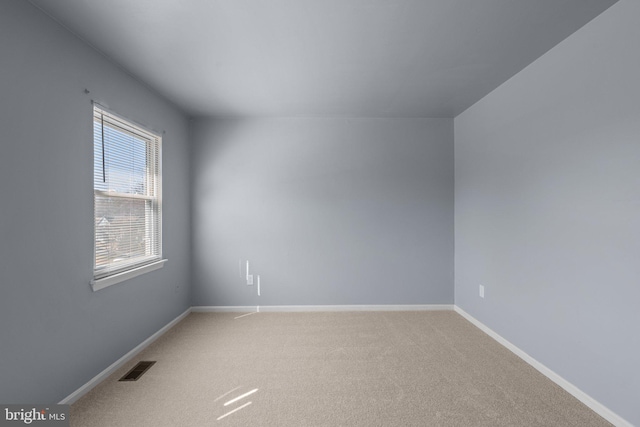 unfurnished room featuring visible vents, light carpet, and baseboards