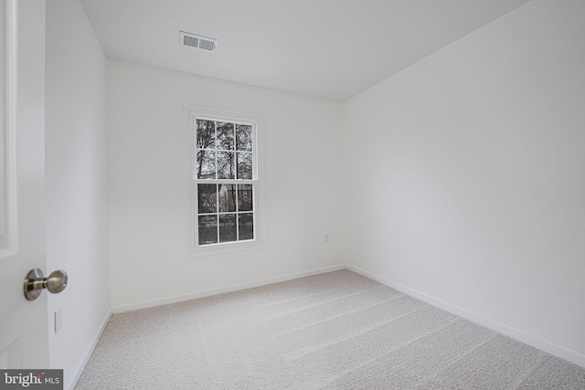 carpeted spare room with baseboards and visible vents