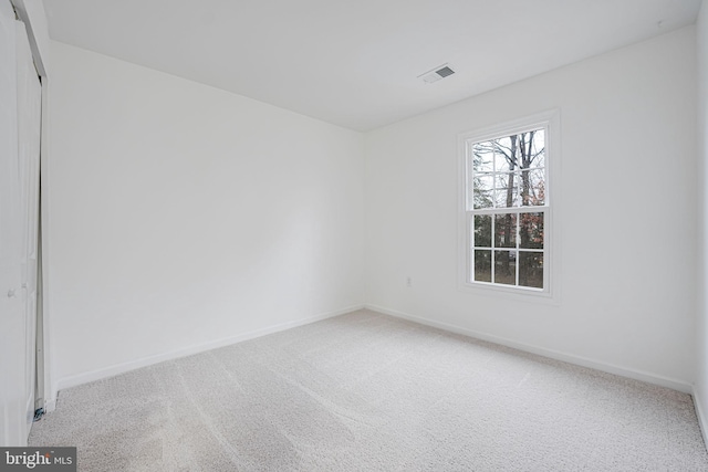 carpeted empty room with visible vents and baseboards