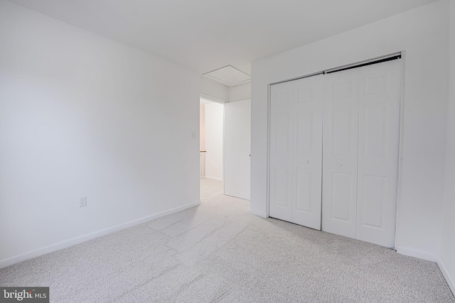 unfurnished bedroom with carpet, a closet, and baseboards