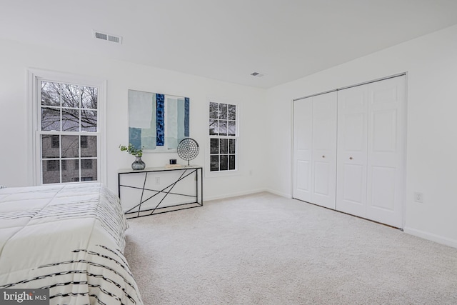 bedroom featuring carpet floors, a closet, visible vents, and baseboards