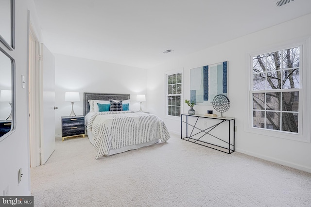 bedroom featuring carpet, multiple windows, visible vents, and baseboards