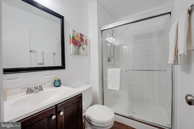 full bathroom with a stall shower, vanity, and toilet