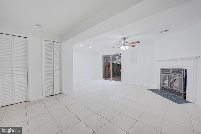 unfurnished living room featuring baseboards, visible vents, ceiling fan, and light tile patterned flooring