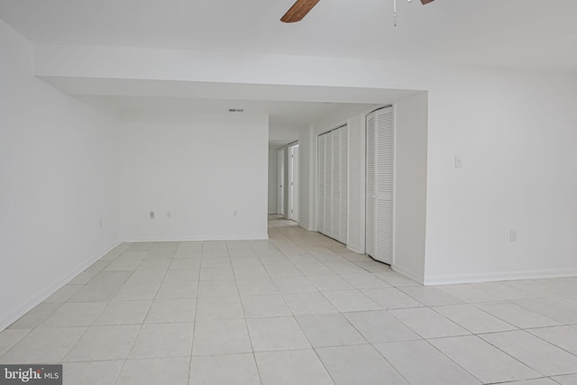 spare room featuring ceiling fan, light tile patterned floors, visible vents, and baseboards