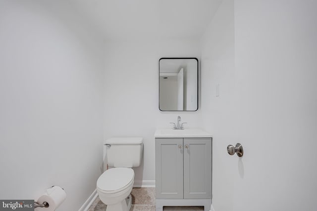 bathroom with vanity, toilet, and baseboards