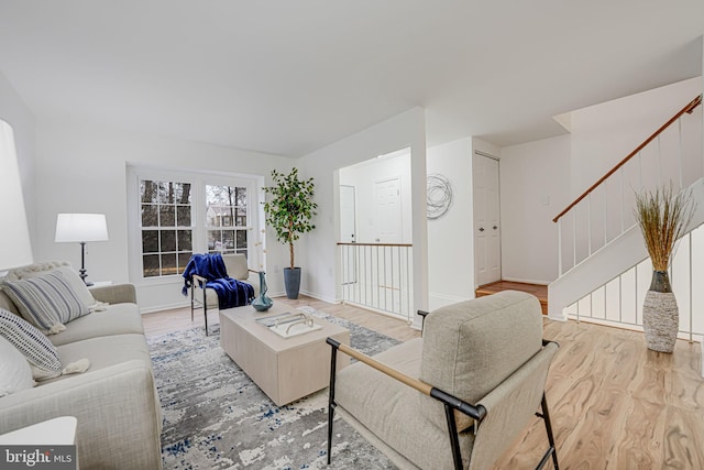 living room featuring stairs, wood finished floors, and baseboards