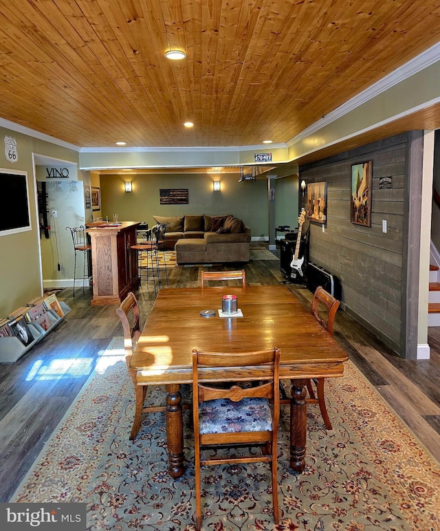 dining space with wood ceiling, crown molding, and wood finished floors