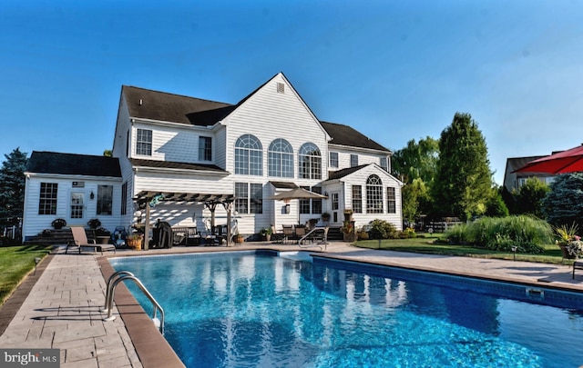 back of house featuring entry steps, a patio area, and an outdoor pool