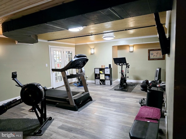 exercise area featuring wooden ceiling, wood finished floors, and baseboards