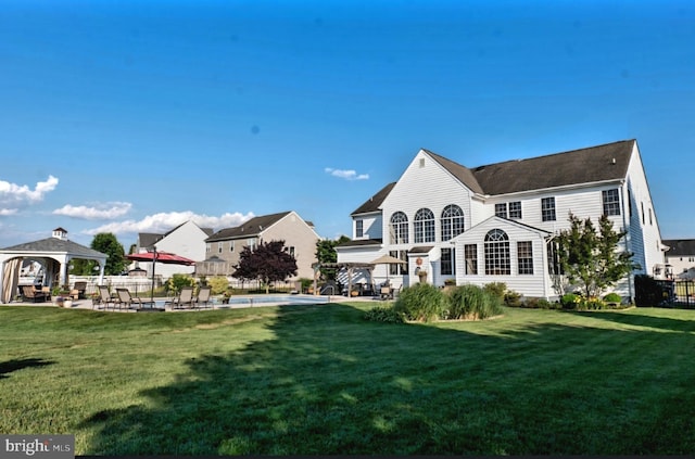 back of house featuring a patio area, a lawn, and a gazebo