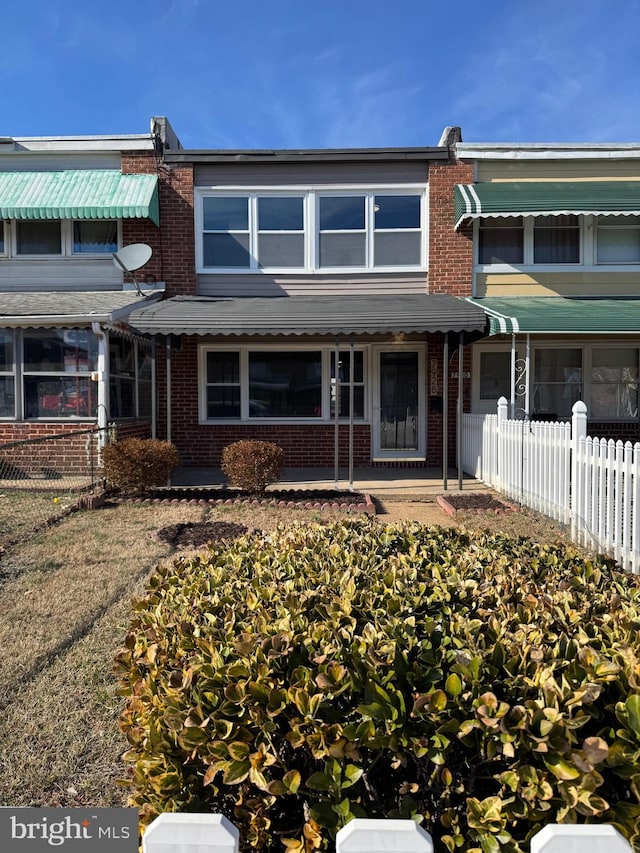 view of property featuring fence and brick siding