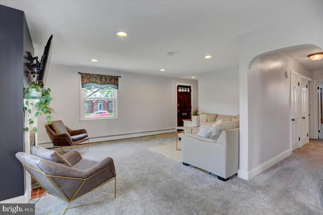 carpeted living area with arched walkways, baseboards, recessed lighting, and a baseboard radiator