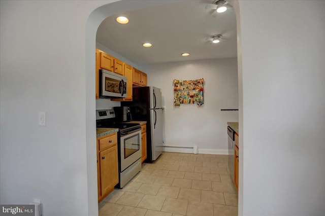 kitchen featuring arched walkways, recessed lighting, stainless steel appliances, baseboards, and dark countertops