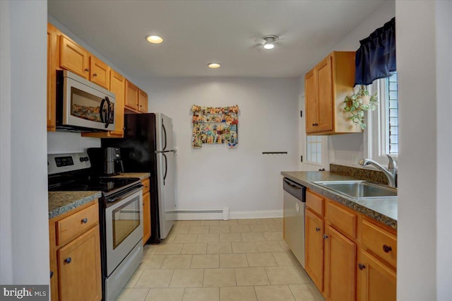 kitchen with recessed lighting, a sink, baseboards, appliances with stainless steel finishes, and dark countertops