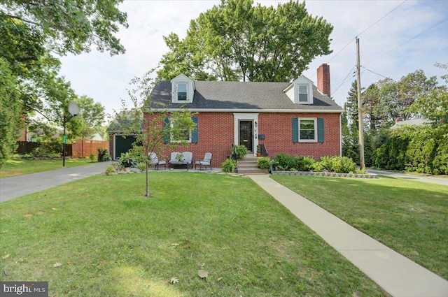 cape cod home featuring driveway, fence, a front lawn, and brick siding