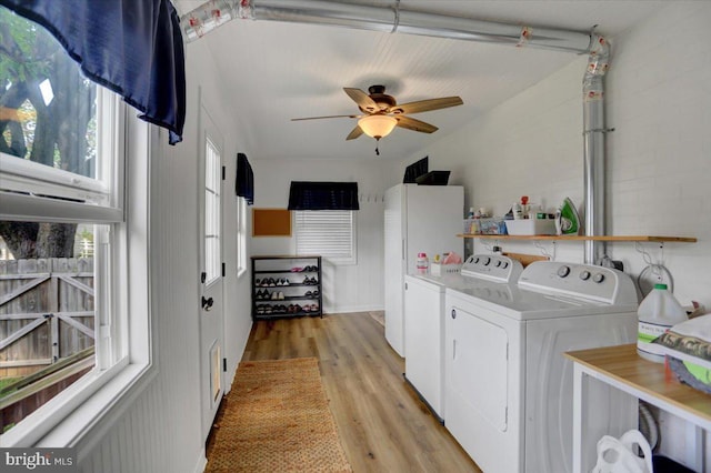 laundry area with laundry area, light wood-type flooring, washing machine and dryer, and a ceiling fan